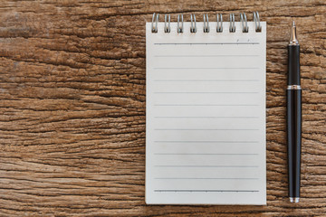 Blank notebook with pen on wooden table, business concept