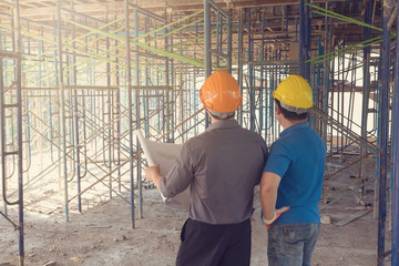 Construction concepts, Engineer and Architect working at Construction Site with blueprint, Vintage effect