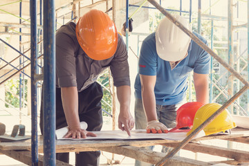 Construction concepts, Engineer and Architect working at Construction Site with blueprint, Vintage effect