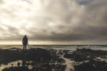 Fisherman Standing on Rocky Shore