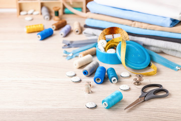 Accessories to sewing - fabric, a thread and a button. Selective focus. Copy space