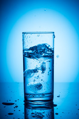 Transparent pieces of ice in a glass of water