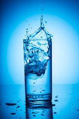 water splash in a glass on the blue background