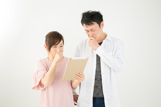 タブレットを見て悲しむ男女