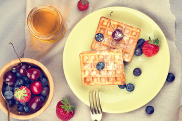 Waffles with berries on wooden background