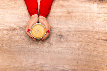 Female hands holding a cup of hot coffee