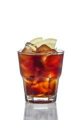 Alcoholic cocktail in rocks glass - Cuba Libre made of cola, lemon and rum. Isolated on white background