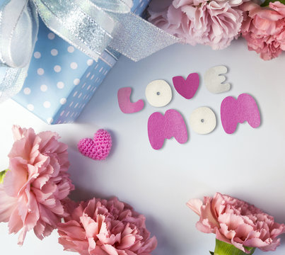 Happy mothers day concept of pink carnation flowers and gift box and heart with love mom text