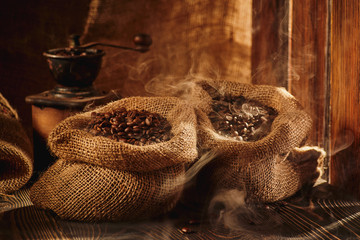 Bag of roasted coffee and coffee grinder  on wooden table.