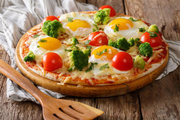 Pizza with eggs, cheese, broccoli, tomatoes and herbs close-up. horizontal