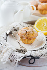 Lemon muffins with poppy seeds on a wooden stand on a light background. Selective focus.