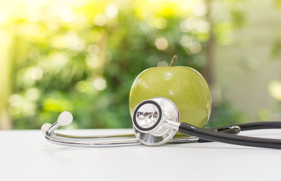 green apple with stethoscope with green background, Fruit is good for health concept