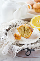 Lemon muffins with poppy seeds on a wooden stand on a light background. Selective focus.
