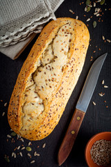 Healthy bread with bran, sunflower seeds, pumpkin, flax and sesame seeds on an old wooden background. Top view.  Selective focus.