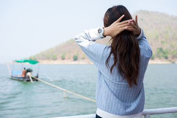 young woman lone moment standing viewing scenery on boat. front of her have lake and mountain are background. this image for travel,nature and portrait