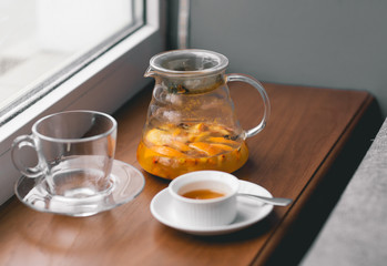 Fruit vitamin tea with orange, honey, sea-buckthorn and spices with glass cup on wood background
