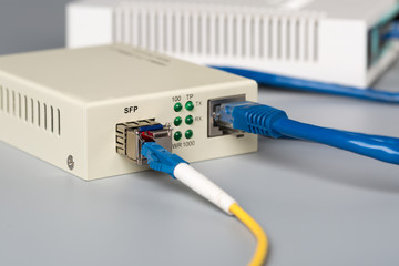 1Gbps optical media converter with SFP module connected to ethernet port SOHO router - obrazy, fototapety, plakaty