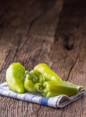 Green peper.Fresh green pepper blue checkered tablecloth on old oak table.