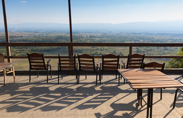 Beautiful autumn mountain landscape in Kakheti view from wooden terrace with chairs. Georgia