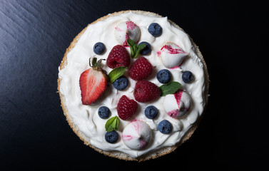 Homemade cake with creamy decor on a black background