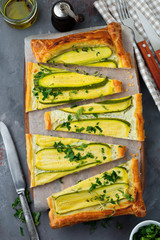 Tart with zucchini, ricotta cheese and parsley on a dark concrete background. Top view. Selective focus.
