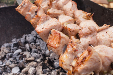 juicy fried meat on skewers outdoors