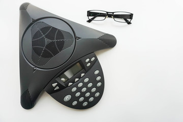 isolated top view of voip IP conference phone with eye glasses on meeting table