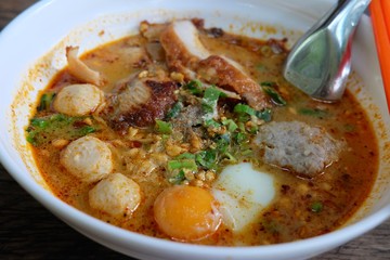 Thai Tom Yum Noodle Soup with egg, pork, fish ball / Spicy noodle in Thai Style is very delicious