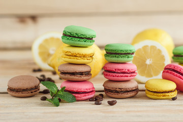 Green, pink, yellow and brown french macarons with lemon and coffee beans