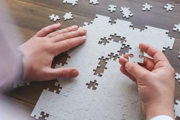 The man puts puzzles in the form of  question mark