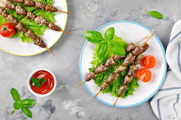 Chicken hearts on a barbecue sticks topped with sesame seeds