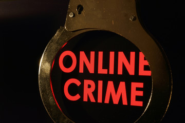 Words Online crime on a monitor and handcuffs.