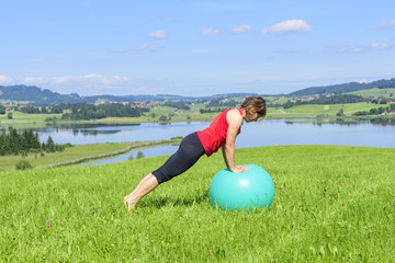 Pilates-Übungen mit Ball im Grünen