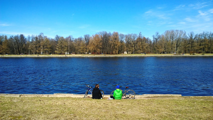 Mother and son are resting on the shore after Cycling. A cool spring day
