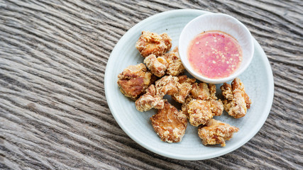 deep fried chicken and spicy sauce on a wooden background.