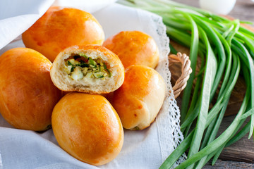 Baked pies made of butter dough with egg and green onions, horizontal