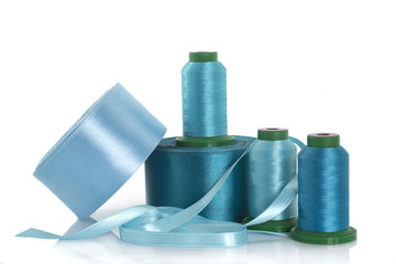 Silk thread and satin ribbons for needlework on a white background