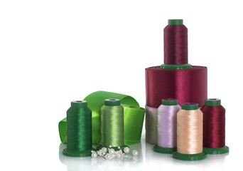 Silk thread and satin ribbons for needlework on a white background