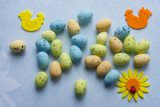 Background with multicolored eggs, two cocks and suflower