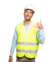 Happy engineer with call gesture against white background