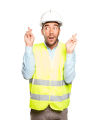 Hopeful engineer with finger cross gesture against white background