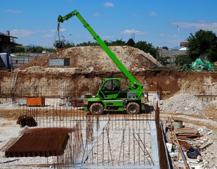 Telescopic handler crane in a new construction site, working to build the building foundation