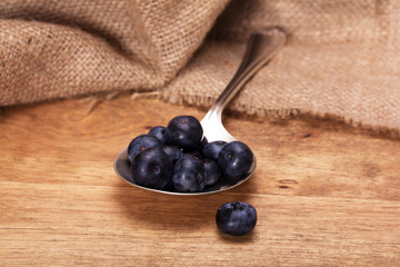 Blueberries and spoon on a rustic background