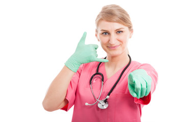 Cute medical nurse making calling gesture and pointing camera
