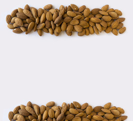 Almonds at border of image with copy space for text. Kernels almonds on a white background. Top view. Vegetarian or healthy eating. Background of almond.