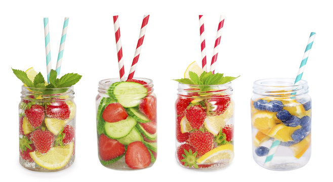 Drinks from strawberries, blueberries, orange, cucumber. Collage of lemonades isolated on white background. Set of different refreshing drink with striped straw. Drinks in a glass jar.