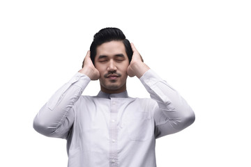 Young asian muslim man in traditional dress praying