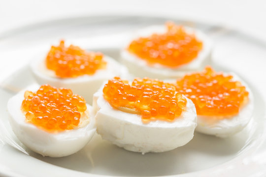Boiled egg with red caviar a culinary dish