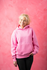 Obraz na płótnie Canvas Woman wearing pink sweatshirt on pink background