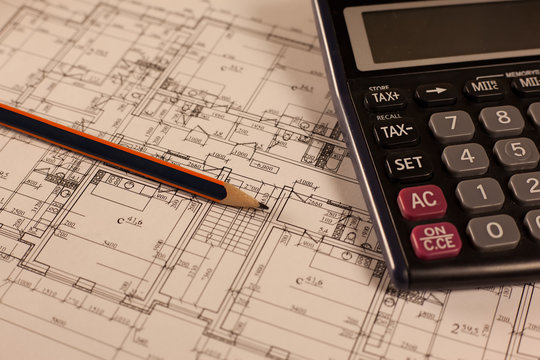 Pencil, calculator and plan of house on wood background